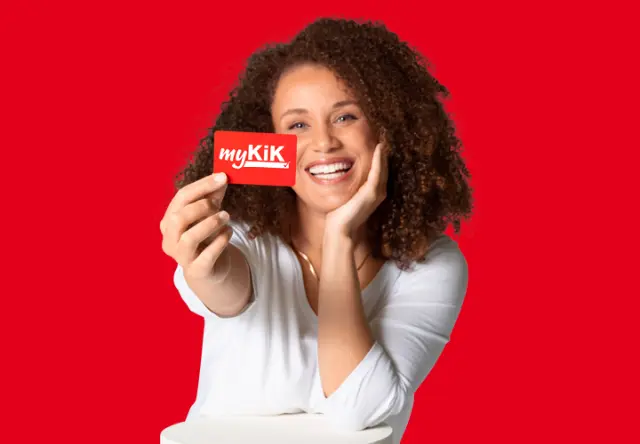 Bespaar 20 % op verzendkosten Een vrouw houdt glimlachend de myKiK-voordeelkaart voor de camera.